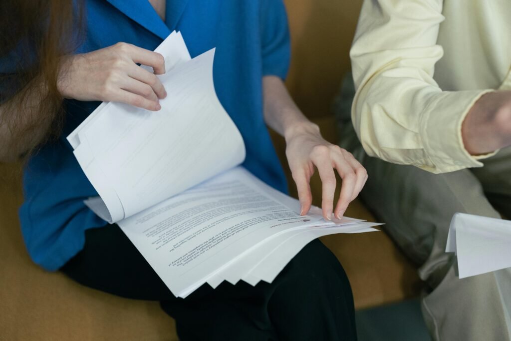 pexels-photo-8453827-8453827 People in professional attire reviewing important documents together on a sofa.